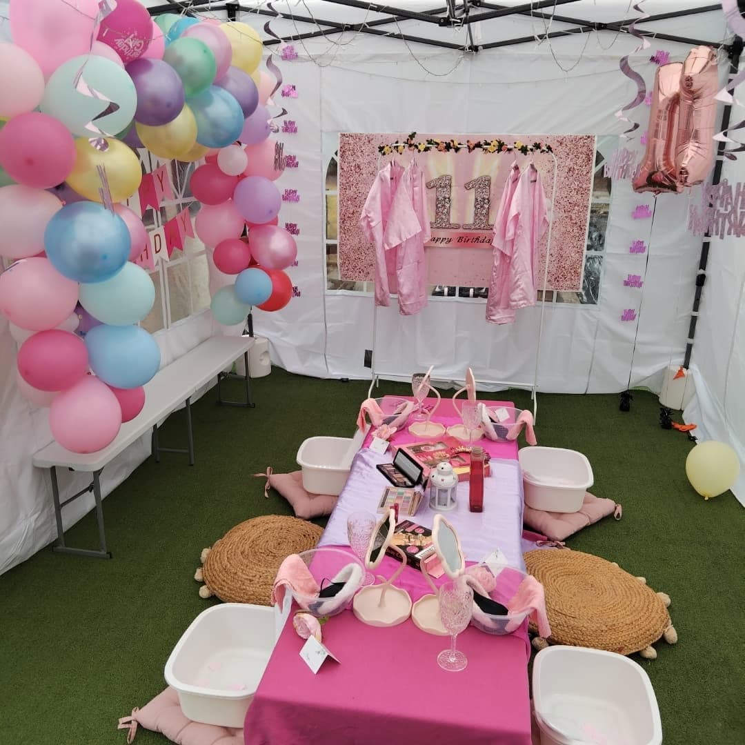 Outdoor pink pamper party with balloons, robes and a low table