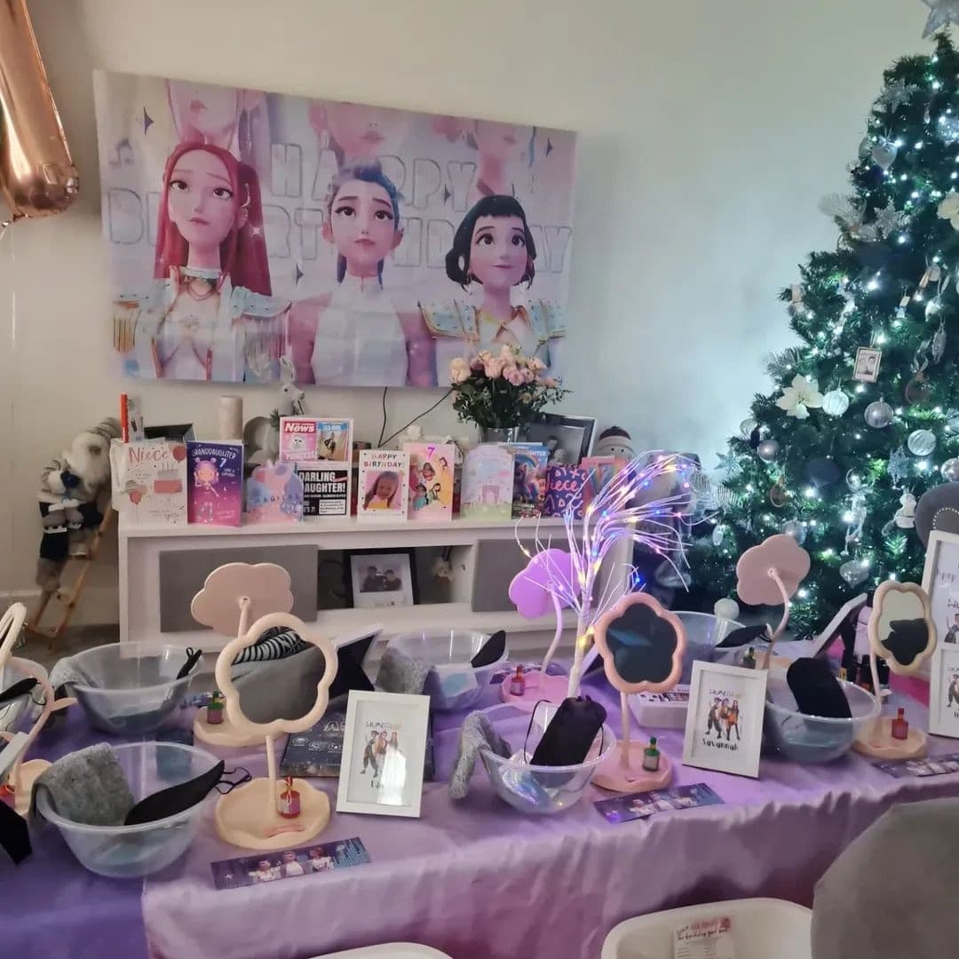 Purple pamper party table with flower mirrors, bowls and colourful fibre optic lights